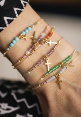 Pulsera cruz colgando