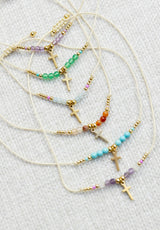 Pulsera cruz colgando